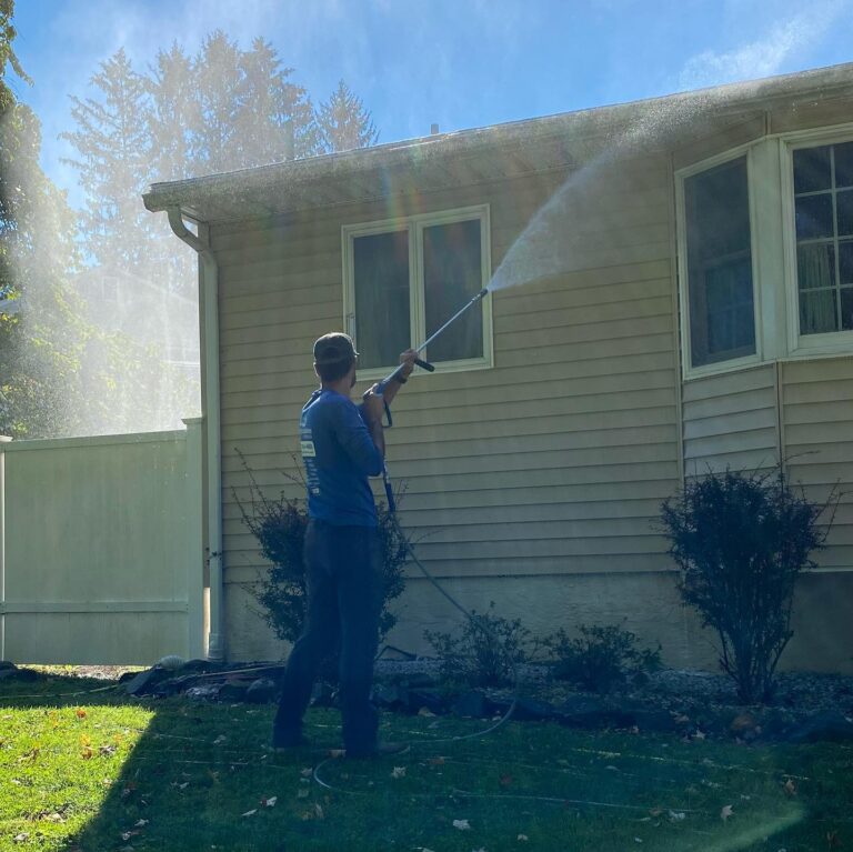 Bright Solutions ProWash technician soft washing a home exterior in Hudson Valley, NY using low-pressure cleaning techniques.