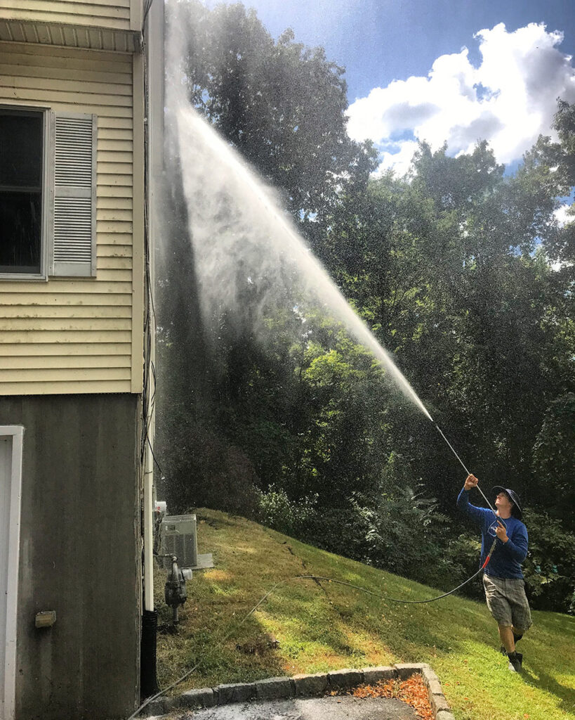 Jason, a Bright Solutions ProWash technician, soft washing a residential house exterior in Hudson Valley