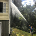Bright Solutions ProWash technician soft washing residential house siding in Hudson Valley to remove dirt, mold, , fungus, moss, and algae